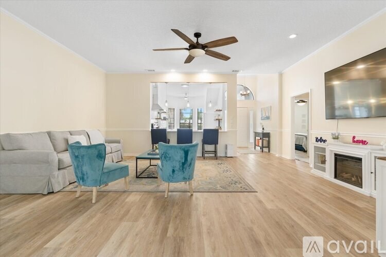 A living room with a white couch, a blue chair, and a wooden floor.