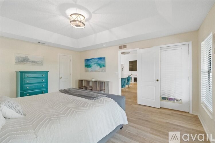 A bedroom with a large bed and a painting on the wall.