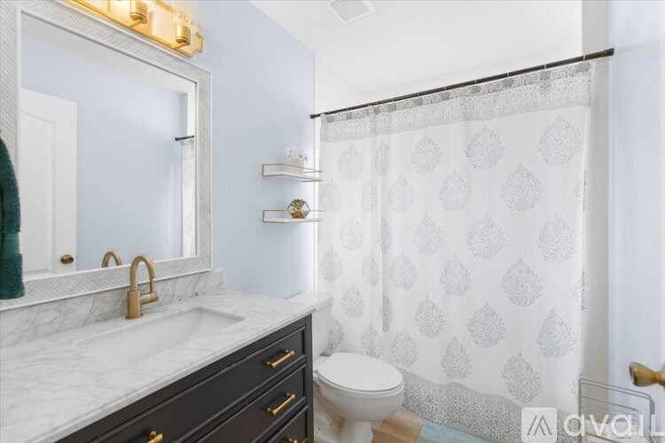 A bathroom with a white sink and a white toilet.