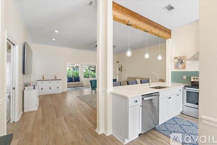 A kitchen with white cabinets and a wooden beam ceiling.