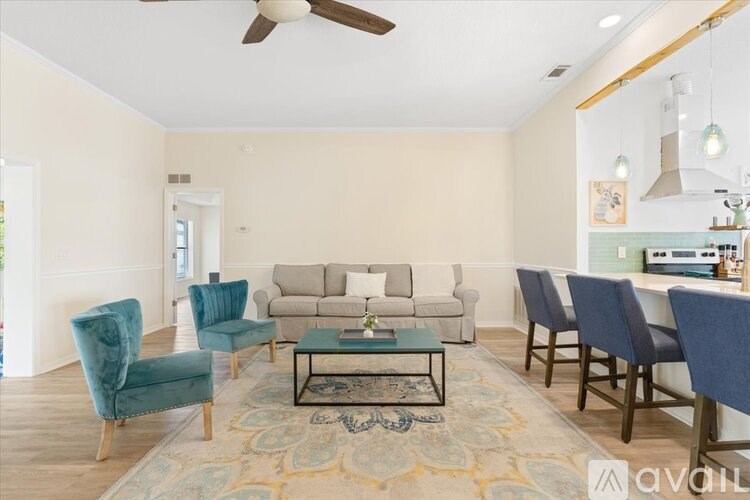 A living room with a blue chair and a glass coffee table.
