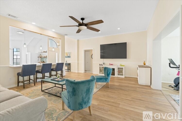A living room with a blue chair and a grey couch.