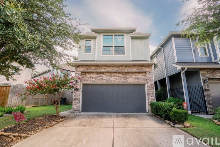 A house with a garage and a driveway in front of it.