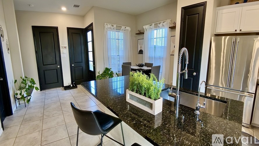 A kitchen with a black chair and a black countertop.