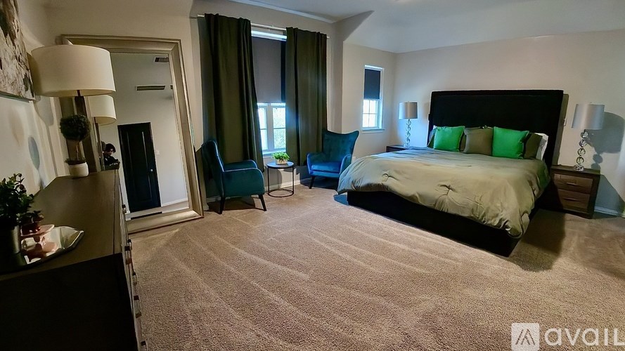 A bedroom with a large bed and a chair.