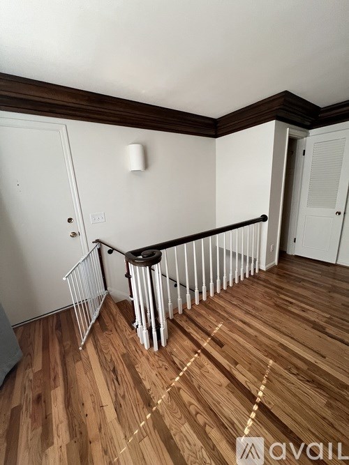A room with wooden floors and a white railing.