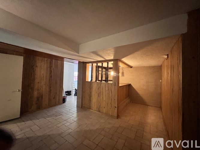 A room with wooden walls and tiled flooring.