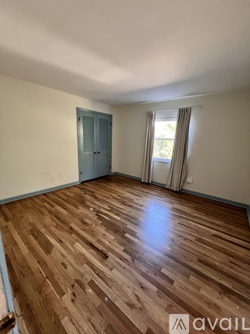 A room with wooden flooring and a door.