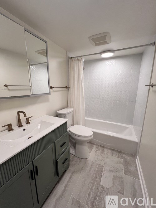 A bathroom with a white sink, toilet, and bathtub.