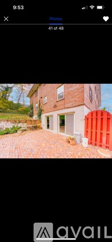 A red container is placed in front of a house.