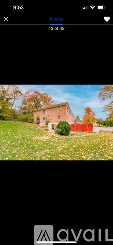 A house with a red fence is surrounded by a field of flowers.
