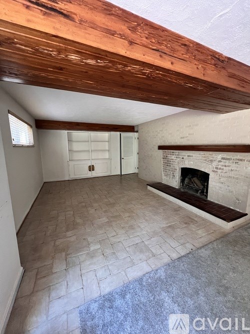 A room with a fireplace and a wooden ceiling.