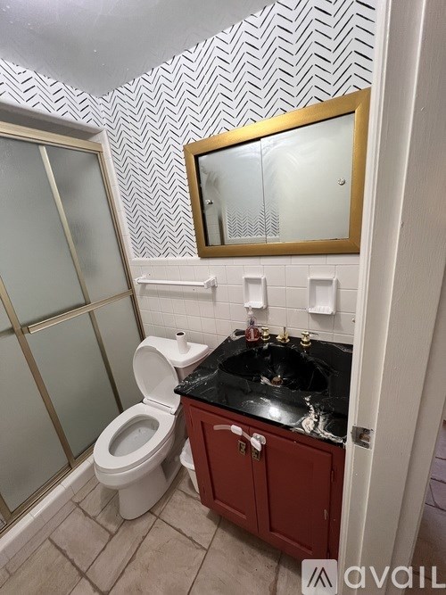A bathroom with a black sink and a white toilet.