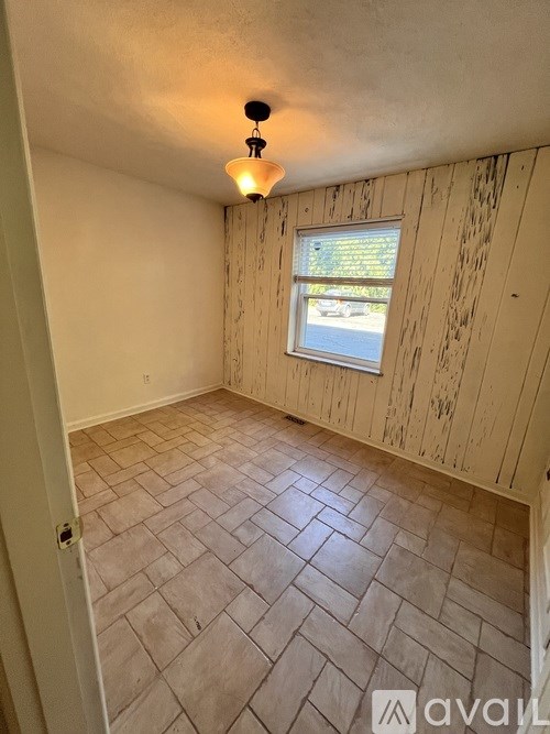 A room with wooden walls and a tiled floor.
