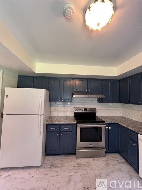 A kitchen with a white fridge and a stove top oven.