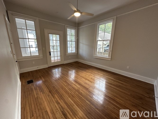 A room with wooden flooring and a ceiling fan.