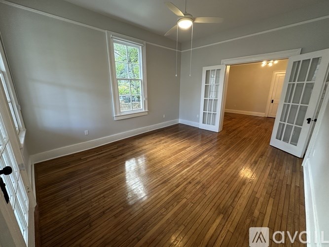 A room with wooden flooring and a ceiling fan.