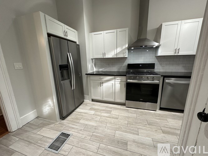 A kitchen with a tile floor and stainless steel appliances.