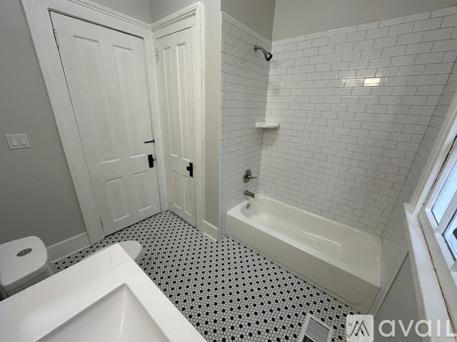 A white bathroom with a black and white floor.