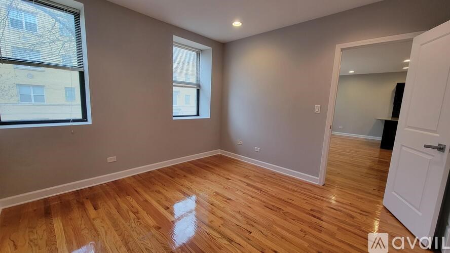 A room with wooden flooring and a white door.