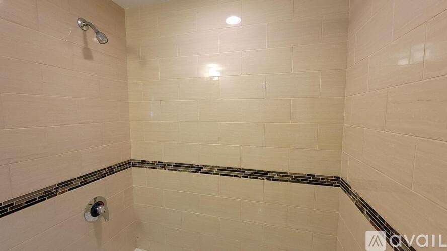 A shower area with a tiled floor and walls.
