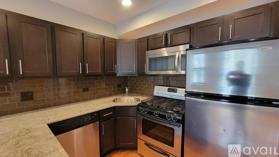 A kitchen with dark brown cabinets and stainless steel appliances.