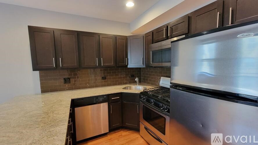 A kitchen with brown cabinets and a stainless steel oven.