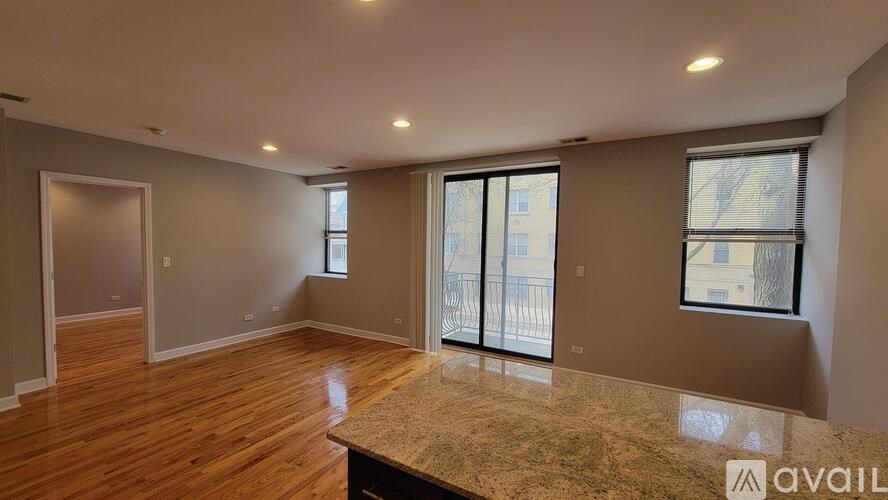 A spacious room with wooden floors and a large marble countertop.