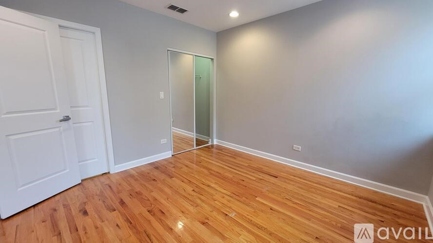 A room with wooden flooring and a white door.