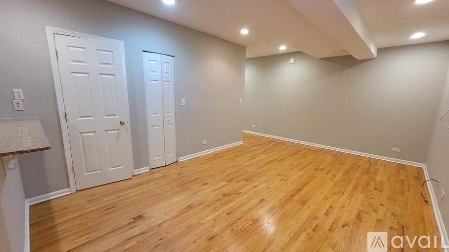 A room with wooden flooring and two doors.