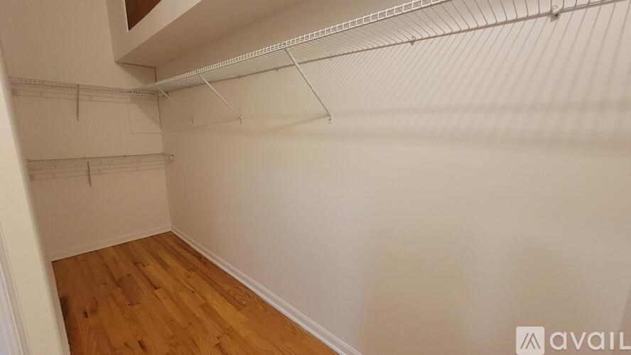 A room with wooden flooring and white walls.