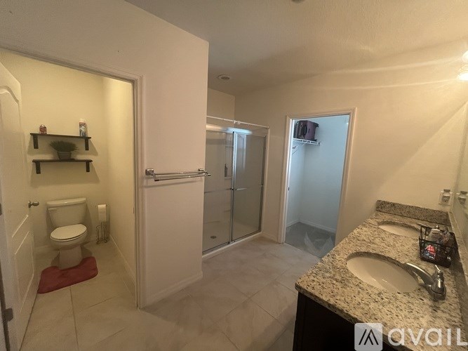 A bathroom with a toilet, sink, and shower.