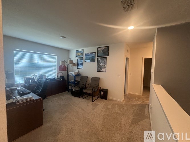 A living room with a couch, chair, and pictures on the wall.