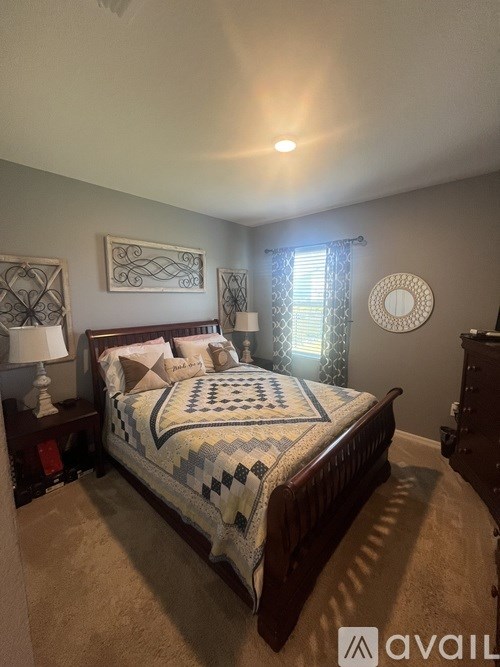 A bedroom with a bed, nightstands, and a window.