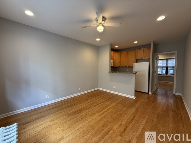 A room with wooden flooring and a ceiling fan.