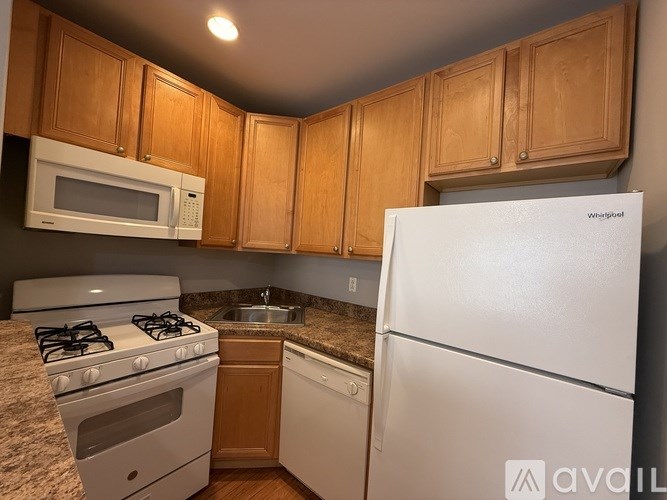 A kitchen with a white refrigerator, white stove, and white microwave.