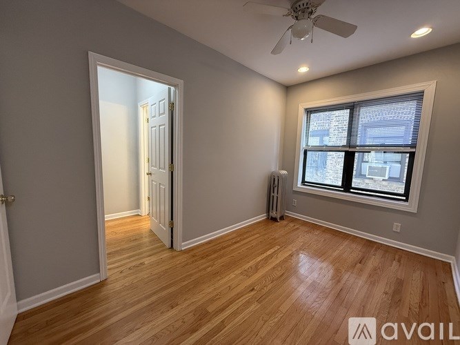 A room with wooden floors and a ceiling fan.