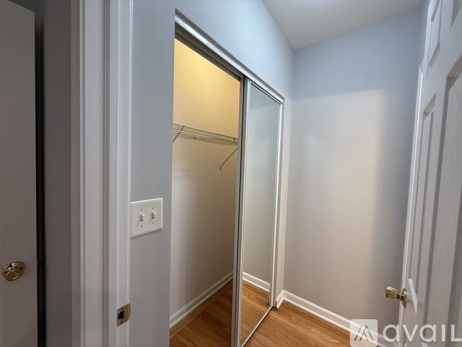 A room with a white door and a wooden floor.
