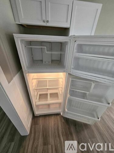 A white refrigerator with its door open and shelves visible.