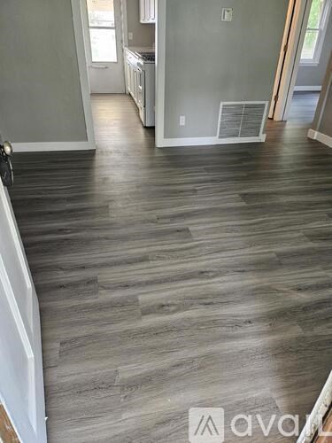 A room with wooden flooring and a white wall.