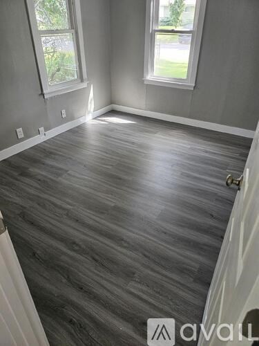 A room with grey flooring and a white door.