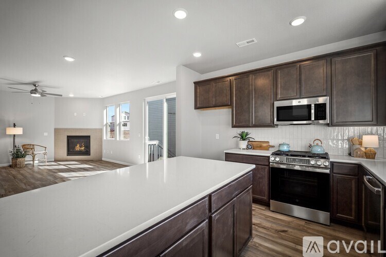 A modern kitchen with dark wood cabinets and stainless steel appliances.