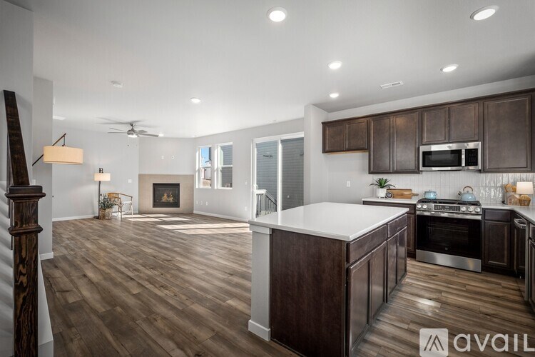 A spacious kitchen with dark wood cabinets and a white island.