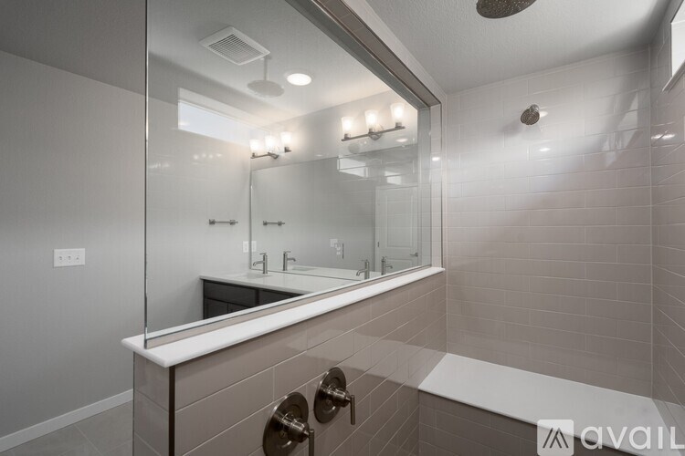 A modern bathroom with a large mirror and a white countertop.