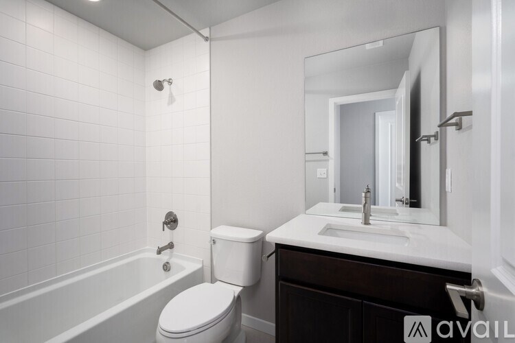 A white bathroom with a toilet, sink, and bathtub.
