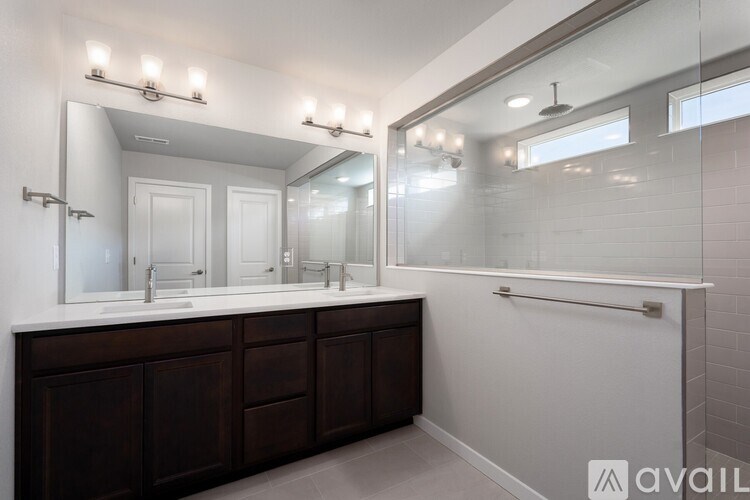 A bathroom with a vanity, mirror, and shower.