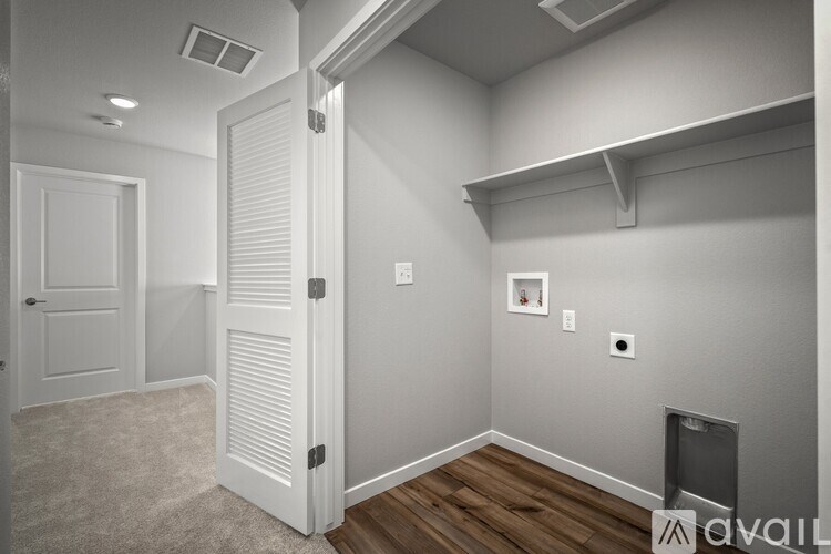 A room with a white door and a wooden floor.