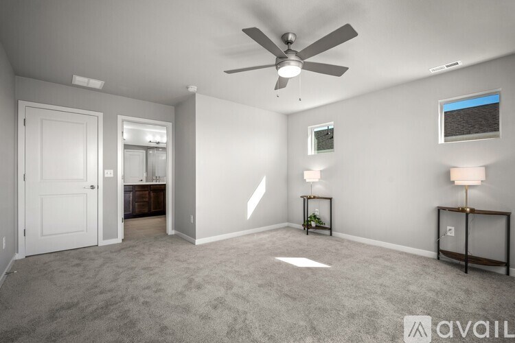 A spacious room with a ceiling fan and a carpeted floor.