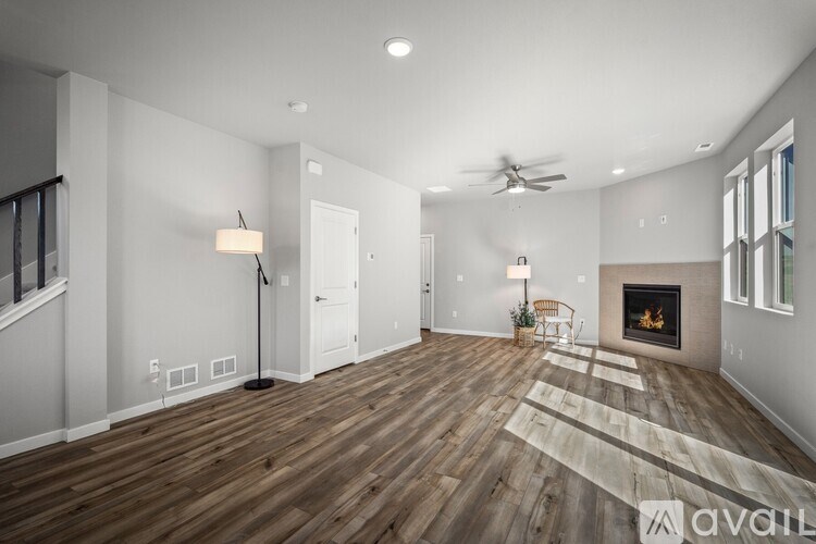 A spacious living room with a fireplace and a rug.