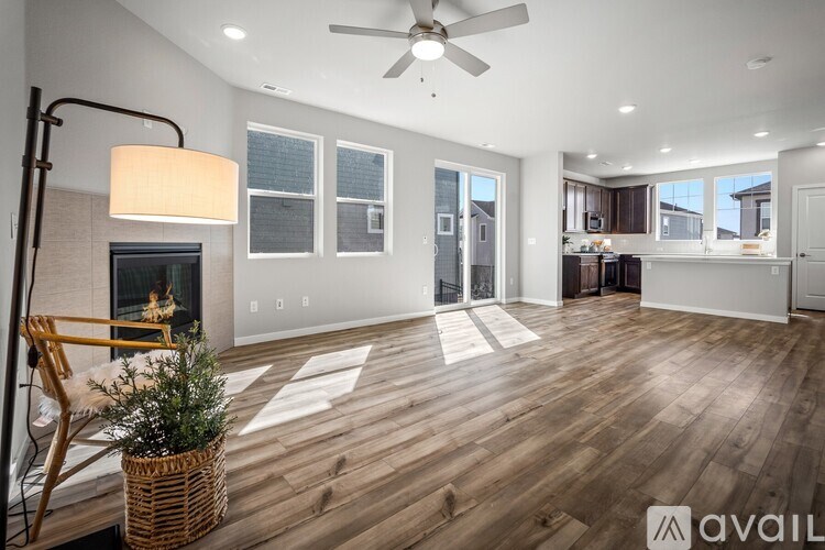 A room with a fireplace, a chair, and a plant in a basket.
